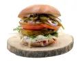 Pikantny jalapeno burger z pomidorem, cebulą i sałatą na drewnianym krążku. Zastanawiasz się nad jego kcal?