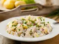 Pyszna, oryginalna kartoffelsalat z ziemniaków, ogórków kiszonych i cebuli, posypana szczypiorkiem.