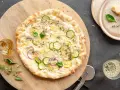 Pyszna pizza bianca z cukinią, cebulą i cytryną, posypana parmezanem i ziołami. Idealna na letni wieczór.
