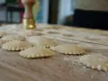 Ravioli co to? Świeżo przygotowane pierożki z ciasta makaronowego, posypane mąką, czekają na gotowanie.