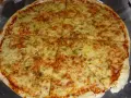 Pyszna pizza margerita z ciągnącym się serem i aromatycznymi ziołami, pokrojona na 8 kawałków.