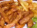Pyszny gyros wieprzowy w sosie, podany z chrupiącymi frytkami i świeżą sałatą. Idealny posiłek dla każdego miłośnika mięsa.