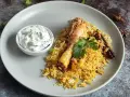 Pyszny kurczak biryani z ryżem, jogurtowym dipem i przyprawami.