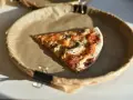 Kawałek pizzy z pieczarkami na papierowym talerzu. Zastanawiasz się, ile kalorii ma pizza?