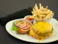 Talerz z hamburgerem, frytkami i ketchupem.