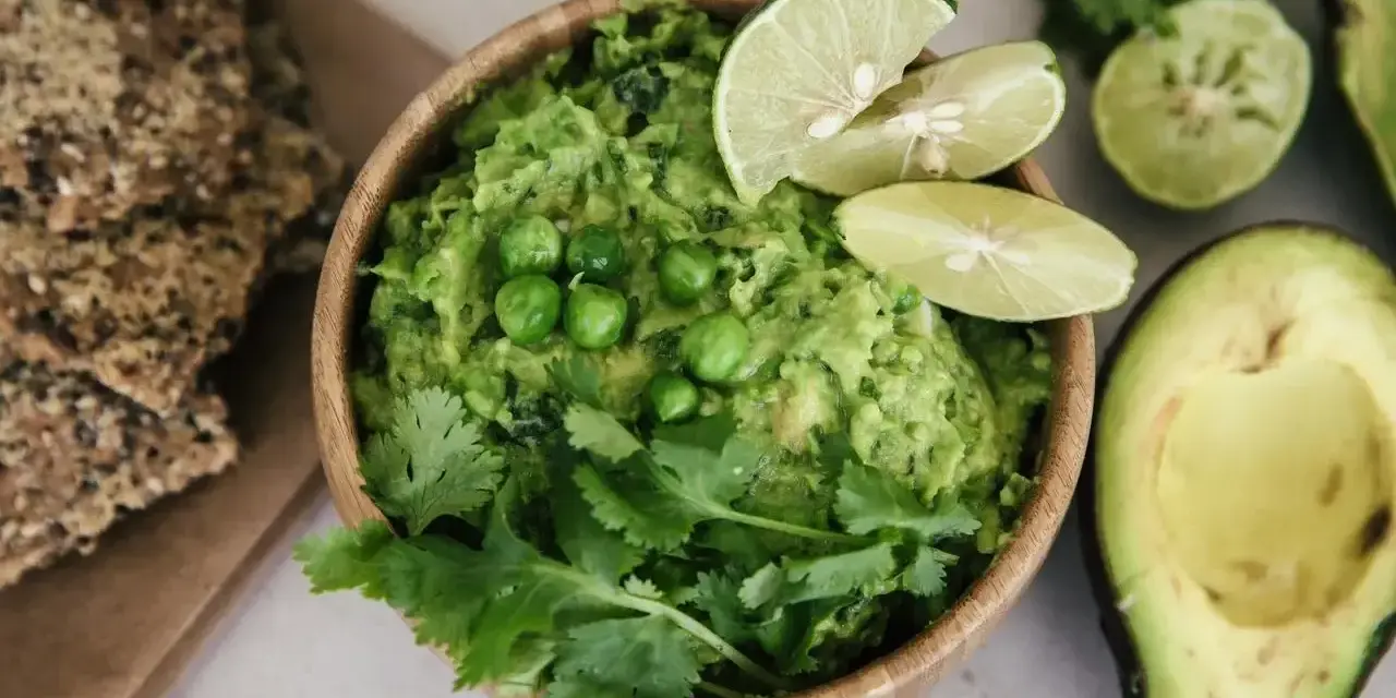 Pyszne guacamole co to? Kremowy dip z awokado, groszkiem, kolendrą i limonką, podany z chrupkimi krakersami.