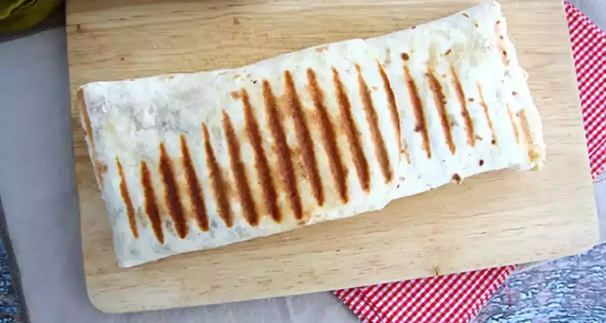 Złocisty, grillowany french tacos na desce. Idealny na szybki lunch.