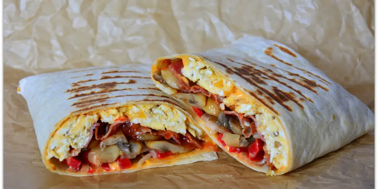 Pyszny wrap jajeczny z boczkiem, pieczarkami i papryką, idealny na śniadanie.