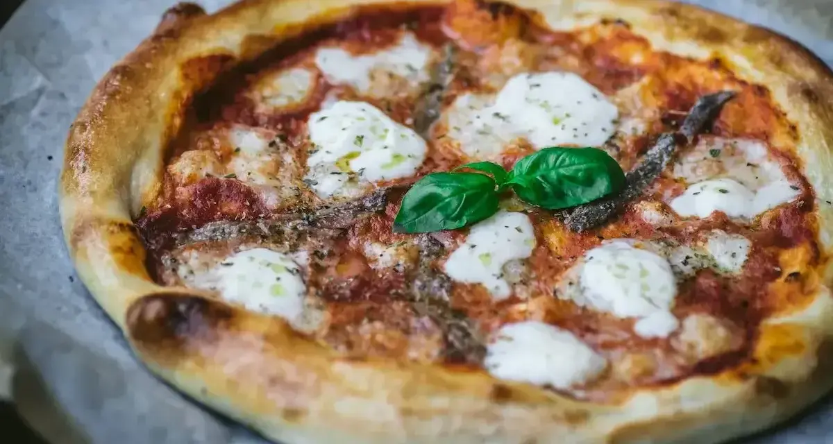 Pyszna pizza z anchois, mozzarellą i bazylią. Jeden z wielu pysznych rodzajów pizzy, idealna na każdą okazję.