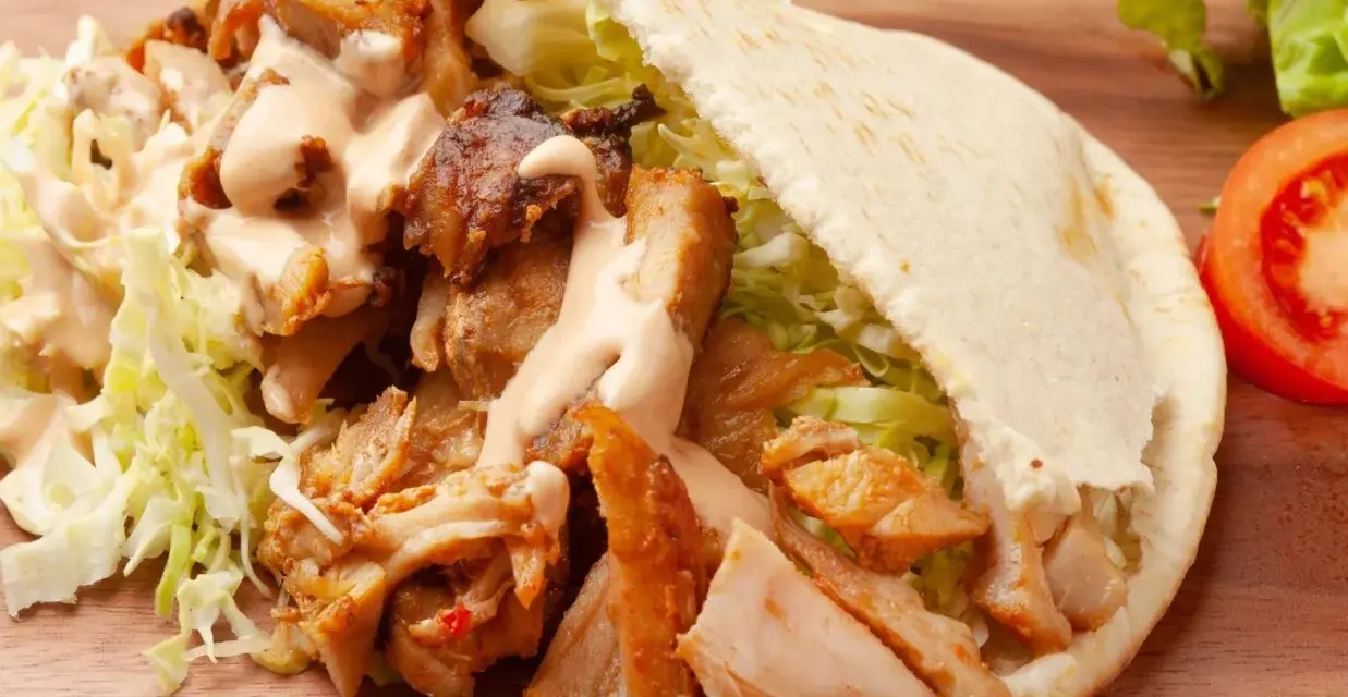 Pyszna bułka kebab z soczystym mięsem, chrupiącą sałatą i kremowym sosem. Idealna na szybki lunch.
