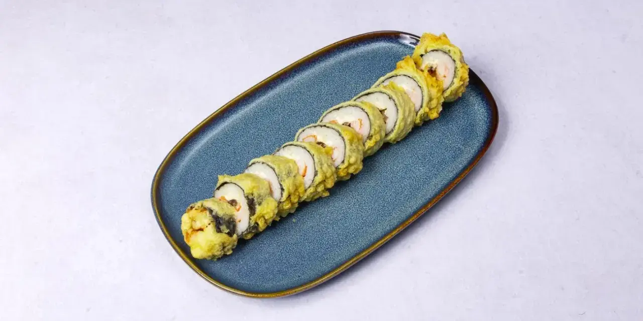 Chrupiące rolki sushi z rybą w tempurze, ułożone na niebieskim talerzu.