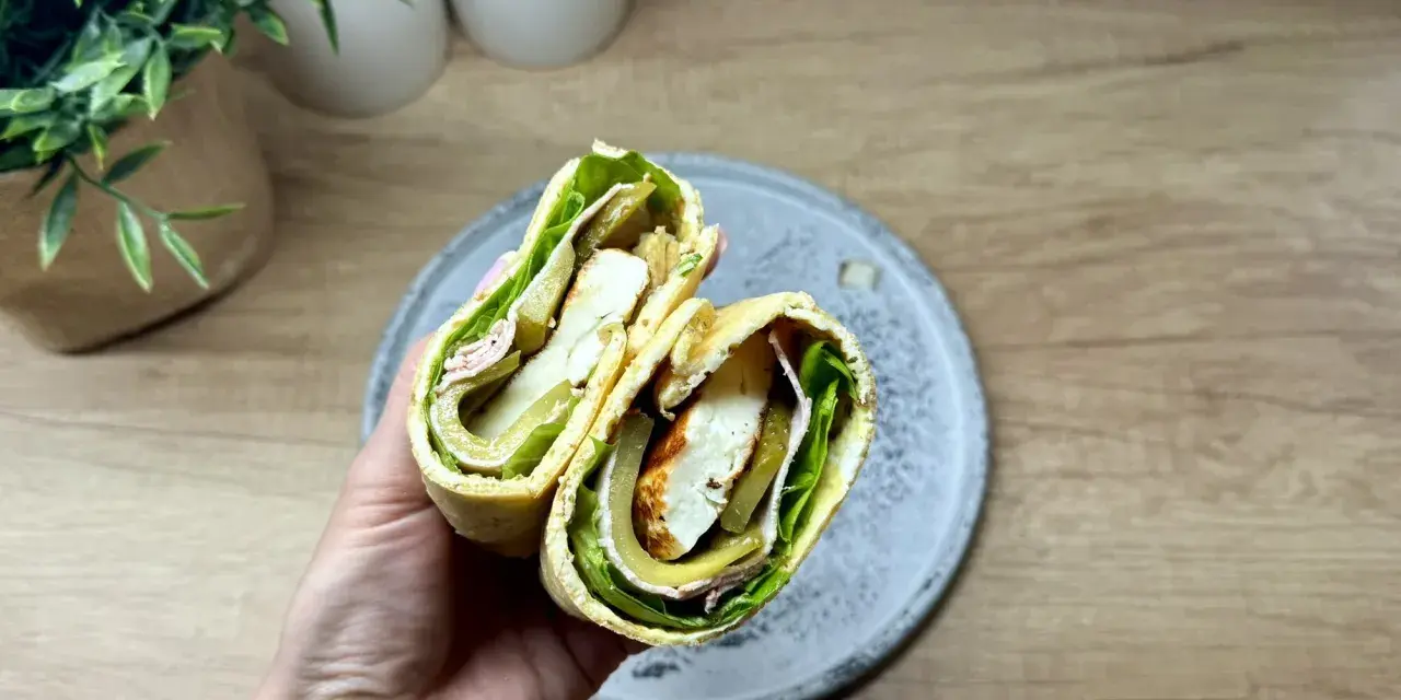 Pyszny wrap wege z serem halloumi, sałatą, ogórkiem kiszonym i oliwkami. Idealny na szybki lunch.