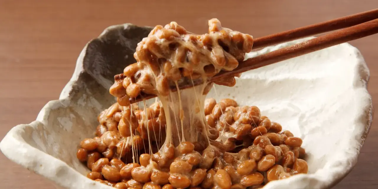 Natto co to? Sfermentowana soja z charakterystyczną, ciągnącą się konsystencją, podana w miseczce, nabierana pałeczkami.