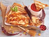 Pyszna quesadilla z serem i papryczkami chili, podana z sosem pomidorowym i ziarnami pieprzu.