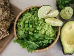 Pyszne guacamole co to? Kremowy dip z awokado, groszkiem, kolendrą i limonką, podany z chrupkimi krakersami.