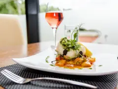 Eleganckie danie rybne z warzywami, ozdobione ziołami i cytryną, idealne do degustacji w stylu kuchni francuskiej.