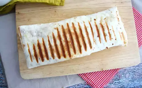 Złocisty, grillowany french tacos na desce. Idealny na szybki lunch.