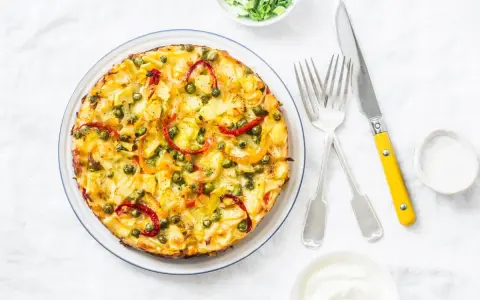 Frittata co to? Złocista, puszysta zapiekanka z ziemniakami, groszkiem i papryką, podana z jogurtem.