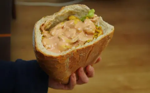 Pyszny kebab na grubym, wypełniony soczystym mięsem i kremowym sosem, czeka na Ciebie.