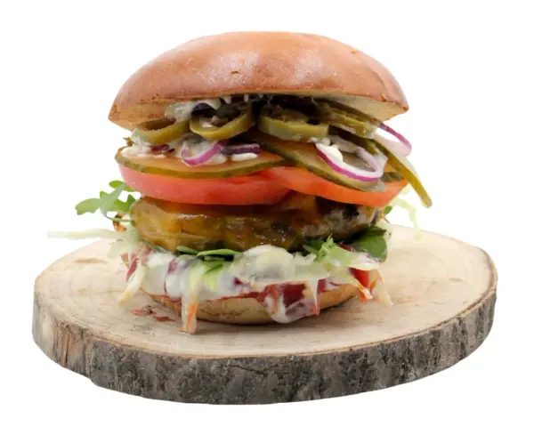 Pikantny jalapeno burger z pomidorem, cebulą i sałatą na drewnianym krążku. Zastanawiasz się nad jego kcal?