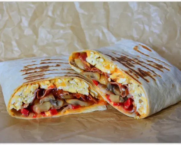 Pyszny wrap jajeczny z boczkiem, pieczarkami i papryką, idealny na śniadanie.