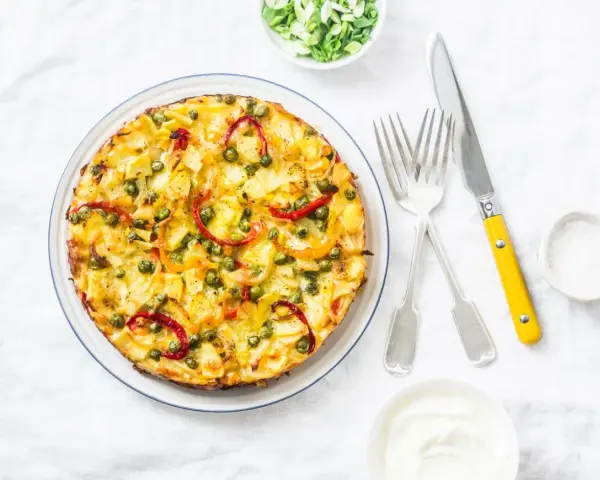 Frittata co to? Złocista, puszysta zapiekanka z ziemniakami, groszkiem i papryką, podana z jogurtem.