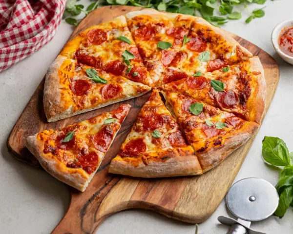 Apetyczna pizza pepperoni z ciągnącym się serem i świeżą bazylią, gotowa do podania.