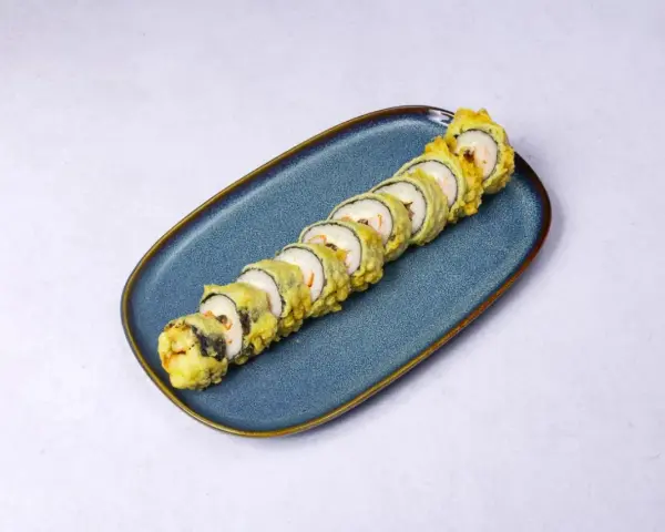 Chrupiące rolki sushi z rybą w tempurze, ułożone na niebieskim talerzu.
