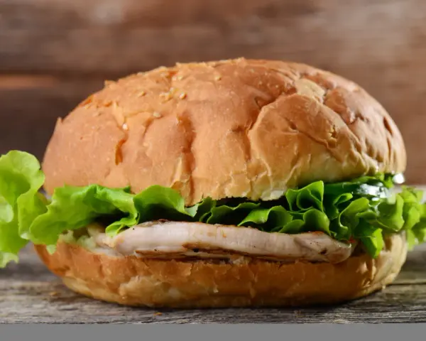 Pyszny chicken burger z chrupiącą sałatą. Idealny na szybki posiłek, z umiarem można cieszyć się jego smakiem i zawartością kcal.