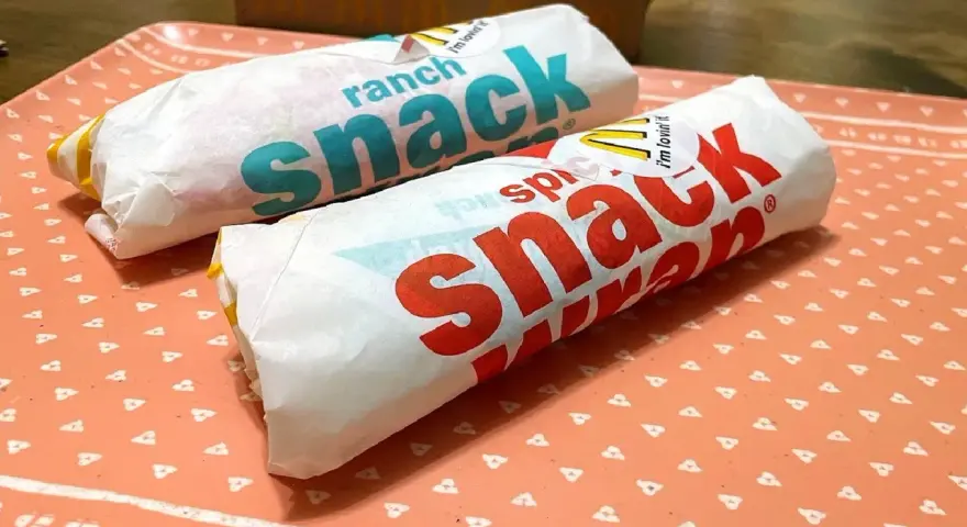Dwa wrapy McDonald's na tacce. Jeden z napisem "spicy snack", drugi "ranch snack". Ciekawe, ile kcal ma wrap z mąki?