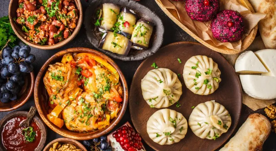 Bogactwo smaków Gruzji: khinkali, fasola, bakłażany, ser i mięso w sosie. Pyszne dania gruzińskie na stole.