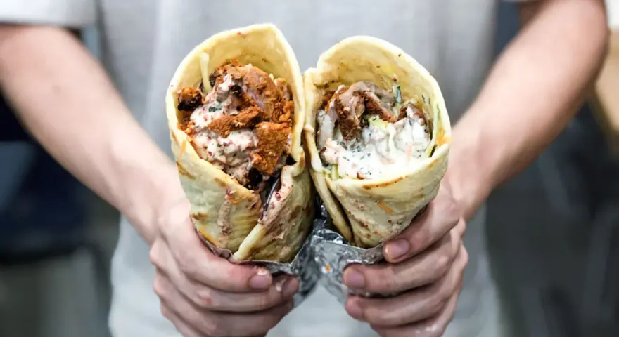 Dwie porcje pysznego, soczystego kebab na cienkim, zawinięte w tortillę, z sosem i warzywami.