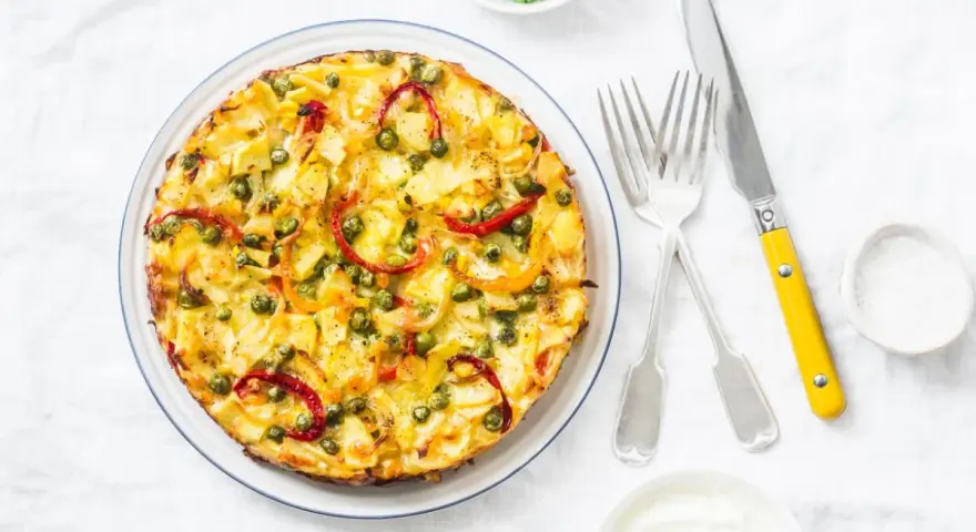 Frittata co to? Złocista, puszysta zapiekanka z ziemniakami, groszkiem i papryką, podana z jogurtem.