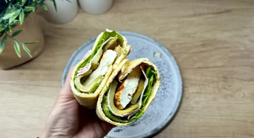 Pyszny wrap wege z serem halloumi, sałatą, ogórkiem kiszonym i oliwkami. Idealny na szybki lunch.