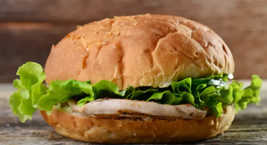 Pyszny chicken burger z chrupiącą sałatą. Idealny na szybki posiłek, z umiarem można cieszyć się jego smakiem i zawartością kcal.