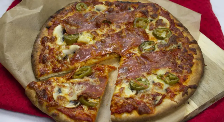 Pyszna pizza z salami, jalapeno i pieczarkami, idealna na wieczór filmowy. Ta **spinata** wygląda apetycznie!