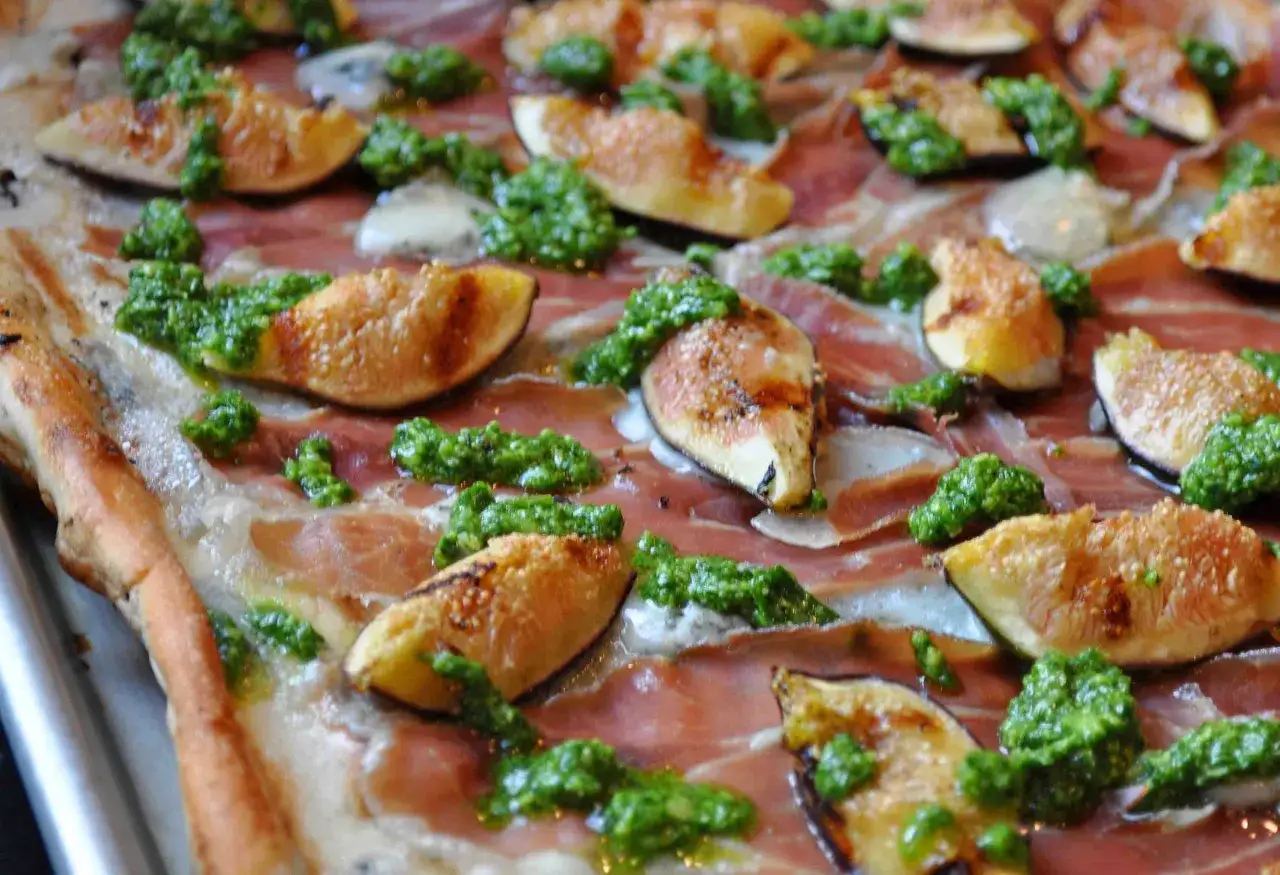 Wykwintna pizza z prosciutto, figami i zielonym pesto.