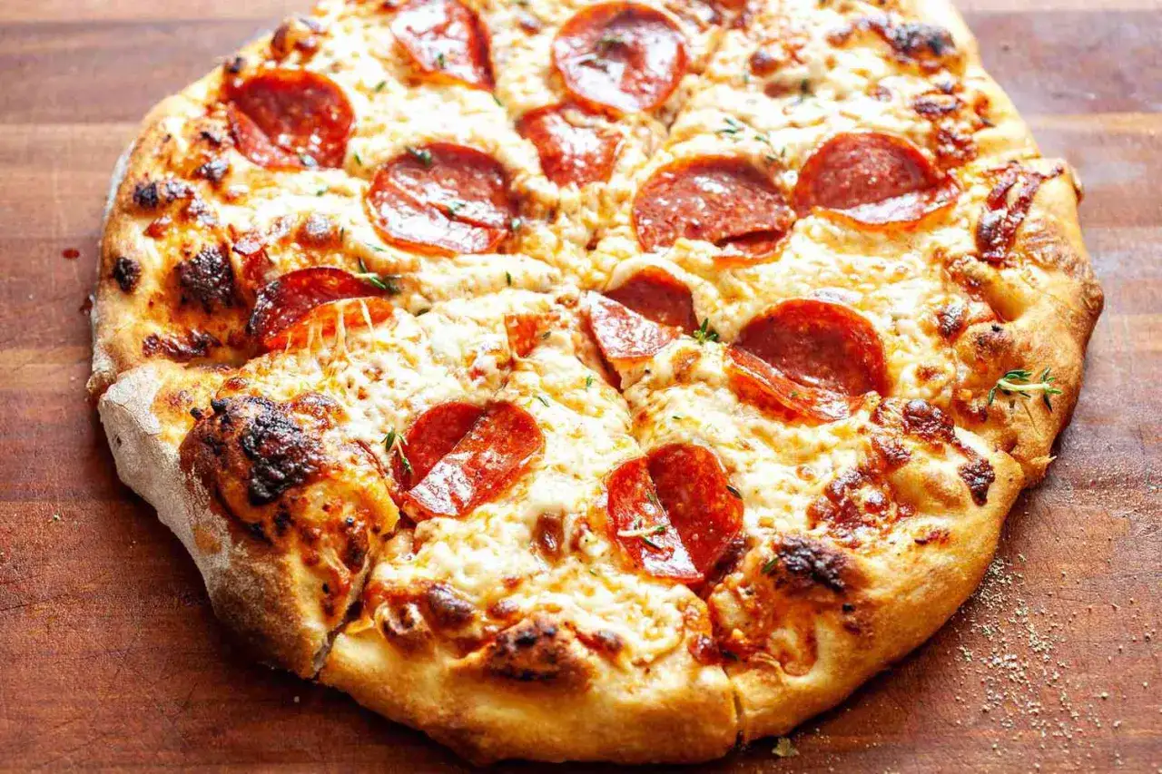 Chrupiąca pizza pepperoni z ciągnącym się serem i ziołami, idealna na szybki obiad.