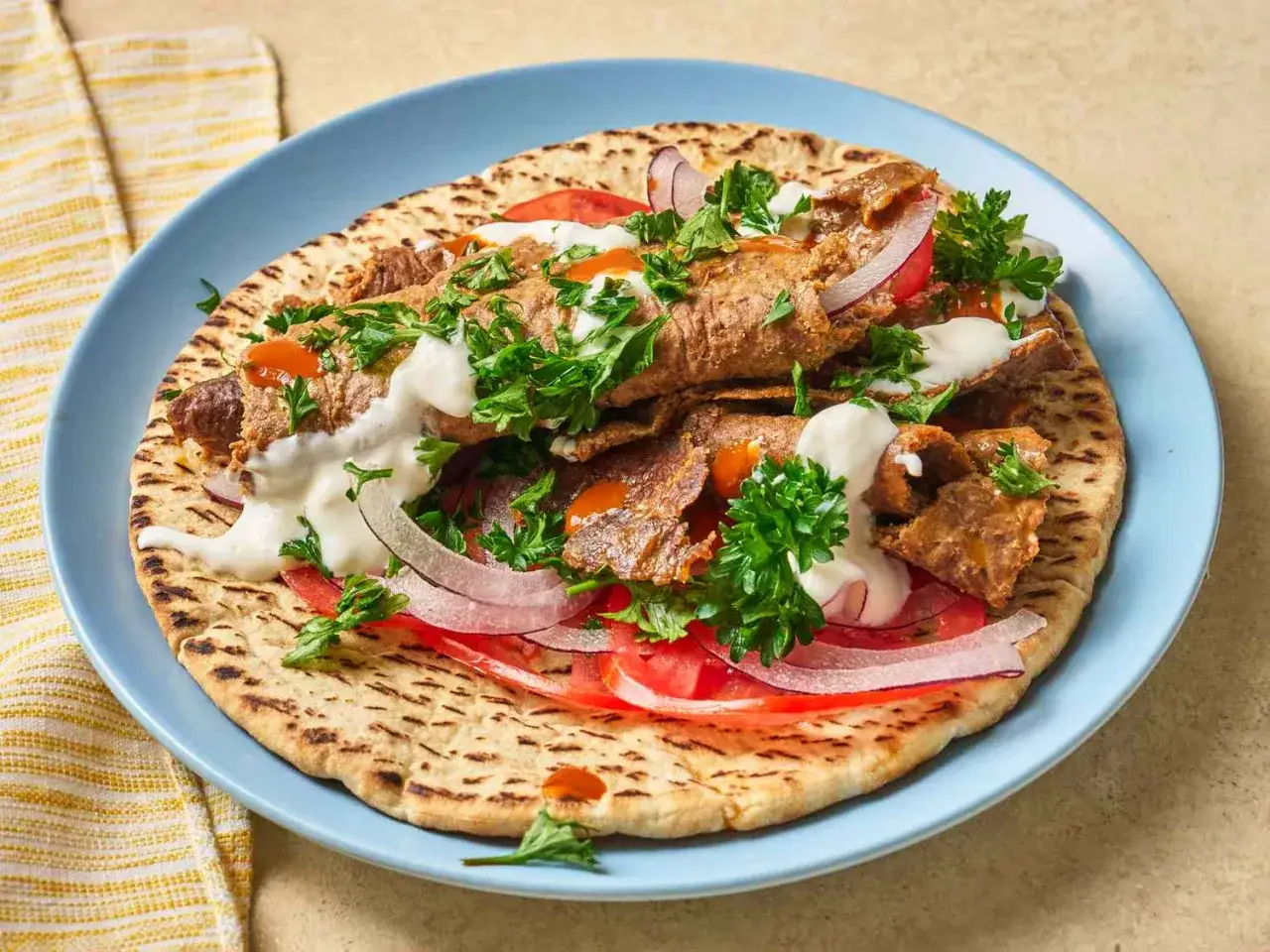 Pyszny kebab na płaskim chlebie z pomidorami, cebulą i ziołami. Czy kebab jest zdrowy? Zależy od składników!