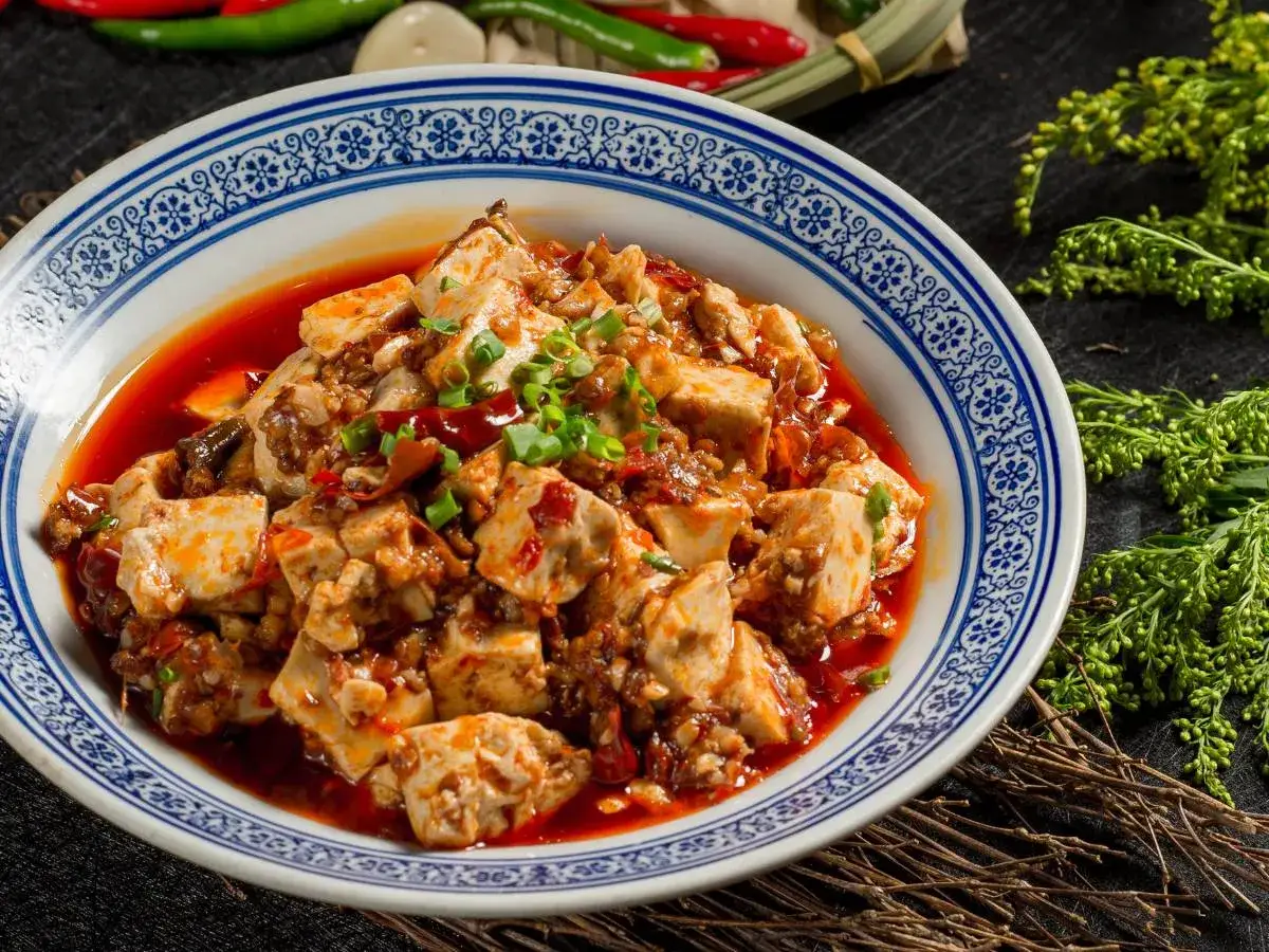 Pikantne tofu po seczuańsku w głębokim sosie, posypane szczypiorkiem.