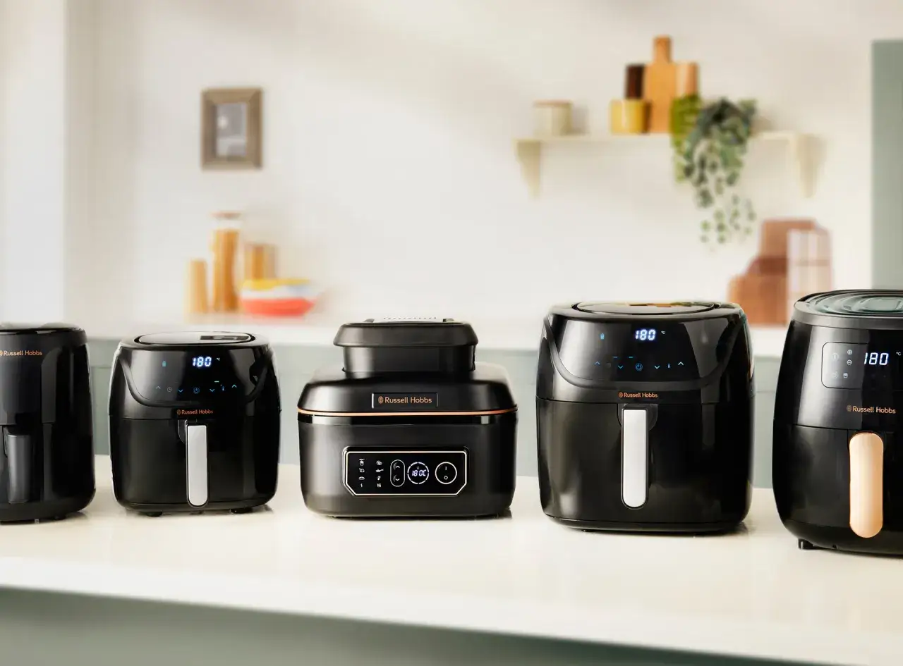 Ranking air fryer: pięć czarnych frytkownic beztłuszczowych Russell Hobbs ustawionych w rzędzie na blacie kuchennym.