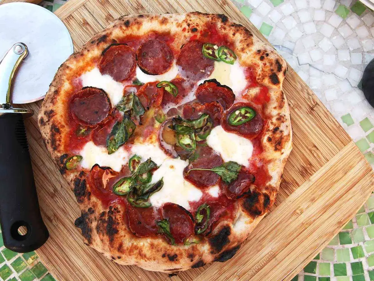 Pikantna spianata calabrese na chrupiącej pizzy z mozzarellą i papryczkami jalapeño. Idealna na ostry wieczór.