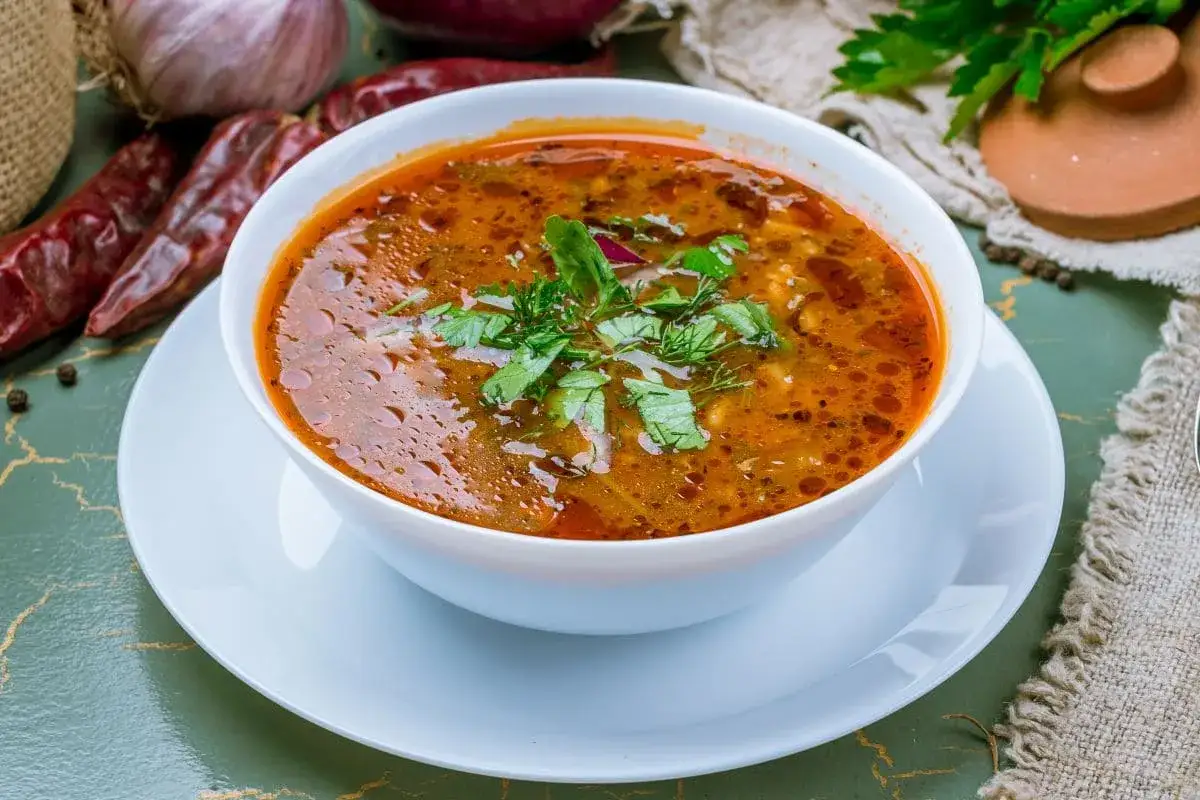 Aromaticzna gruzińska zupa charczo, bogata w smaku, ozdobiona świeżą natką pietruszki i kopru.